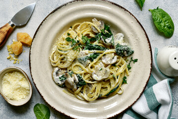 Pasta with spinach and mushrooms in a cream sauce. Top view with copy space.