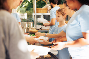 Image showcasing charity workers at outdoor food bank, serving the needy homeless people, providing...