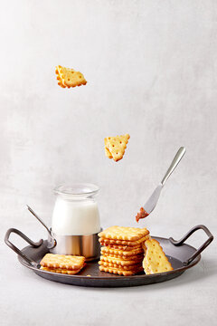 Stack of crackers and milk on a metal tray with a caramel covered knife
