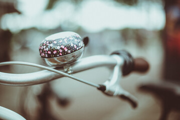 Close-up of a floral bell on a bicycle handlebar