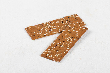 Buckwheat bread with sesame seeds and quinoa, in the form of thin strips, White background. Close-up