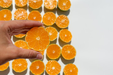 half a tangerine in a woman's fingers