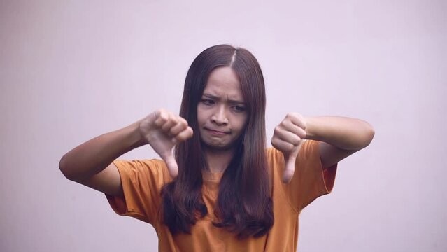 woman holds her thumb upside down as a sign of the worst