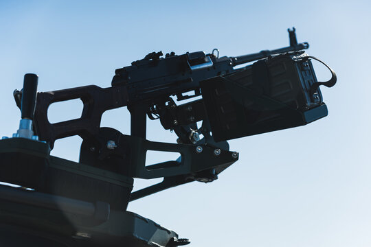 Closeup shot of medium machine gun against the background of sunny blue sky. Belt-fed machine gun. High quality photo