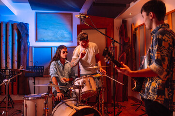 Fototapeta na wymiar Musicians, drummer and guitarist, talking with their producers in music studio.