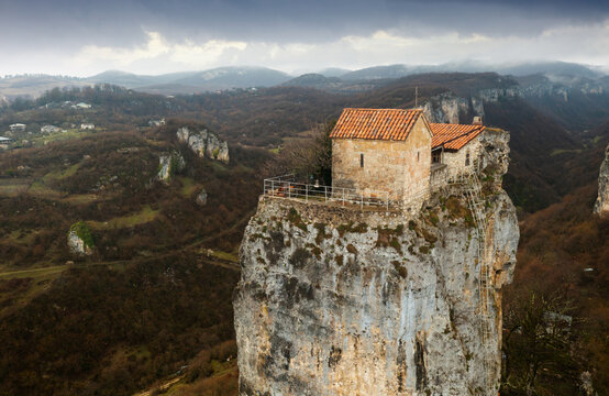 Tourist Georgia. Famous Katskhi pillar near town of Chiatura in Imereti with small monastery and Church of Maxim Confessor on top. Aerial view on cloudy spring day.