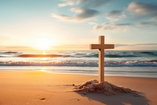 Concept photo of a calm and peaceful beach, with a simple wooden crucifix p in the sand, surrounded by seashells and with the sun rising behind it, reminding us of the timeless message of