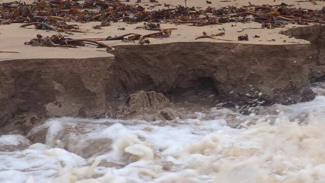 Flood waters from a heavy rain event causing coastal erosion at a beach