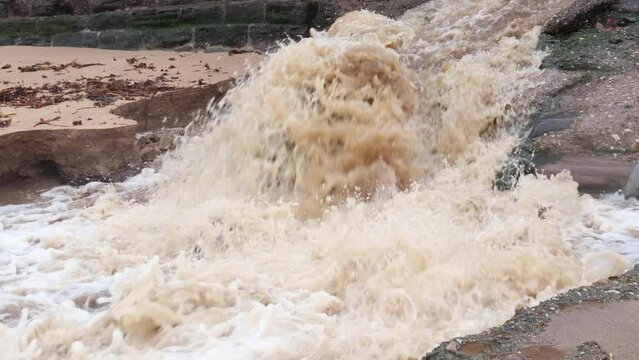 Cascading flood waters causing coastal erosion at a beach after heavy rain