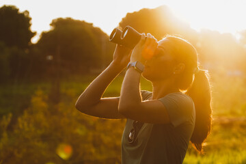 Woman looking through binoculars at the nature of Brazil. Beautiful sunset view of the Pantanal,...