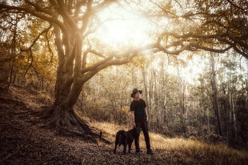 man with his black dog in the forest at sunset, in Sierra de Guadalupe state of Mexico