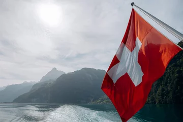 Fotobehang A Swiss flag at the stern of a passengers boat on the lake of Lucerne, Switzerland. © Andrii
