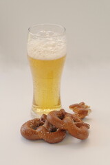 Foamy Beer in Pilsner Glass and Two Hard Pretzels