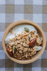 Close up of homemade cereal granola breakfast in wooden bowl, putting on table.