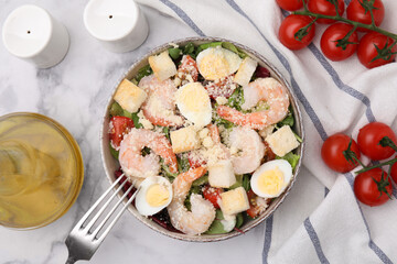 Delicious Caesar salad with shrimps served on white marble table, flat lay