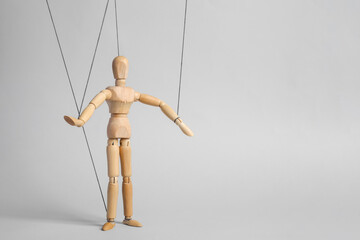 One wooden puppet with strings on light grey background. Space for text