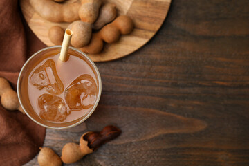 Tamarind juice and fresh fruits on wooden table, flat lay. Space for text