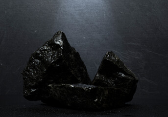 black stones on a dark background for a product presentation podium