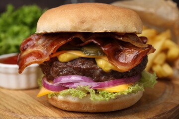 Tasty burger with bacon, vegetables and patty on wooden board, closeup