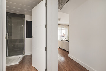 A hall with access to a bathroom and a hallway that leads to other rooms