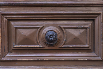 metal handle on access portal to a period building with a wooden door