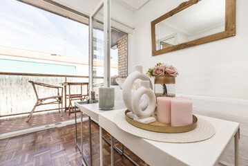 Decorative objects on a tray on extendable coffee tables in a living room next to a terrace with views of the city