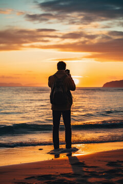 silhouette of a photographer taking landscape photos on a beautiful beach at sunrise or sunset