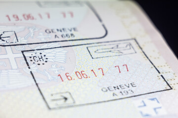 Selective blur on a Swiss passport stamp on a serbian passport, from Geneva Airport border crossing called Geneve Aeroport, abiding by European union Schengen passport stamps regulations. - obrazy, fototapety, plakaty