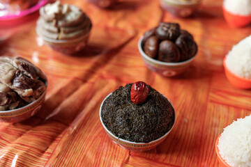 A bowl of Nostoc with a red date on top. Ritual offerings to deity on a temple altar. Chinese sacrificial ceremonies for traditional festivals. 

