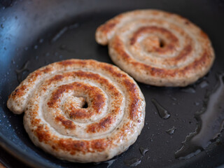 Traditional German Bratwurst Snail Sausages Sizzling in a Pan