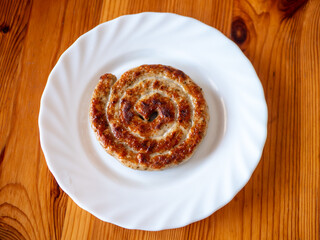 Traditional German Delicious Bratwurst Snail Sausage on a White Plate