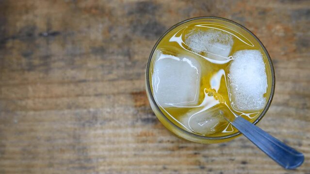 Slowly zooming out: a passion fruit caipirinha cocktail on the table. A glass of sparkling caipirinha on the table. A bubbly passion fruit caipirinha recipe: cacha&ccedil;a, sugar, ice, passion fruit juice. 