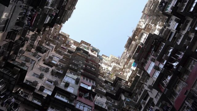 Cinematic shot of a large claustrophobic densely populated apartment building exterior in Quarry Bay, Famous Monster building facade, Hong Kong