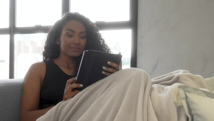 beautiful young black woman sofa relaxing happy smiling reading book close