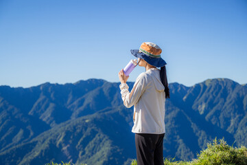 Hike woman drink of water over the mountain - obrazy, fototapety, plakaty