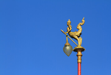 Fototapeta na wymiar Gold lamps and lighting pole background with a blue sky,at Wat Ban Ngao (Temple), Ranong, Thailand