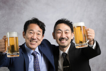 A businessman toasting with a draft beer looks at the camera at an end-of-year party or a New Year's party.