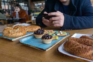 Man using mobile phone to take a photo of food in a cafe