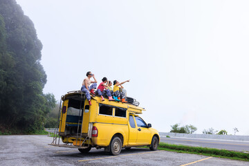  teenager girl friends group sitting on the roof of yellow a minibus, chiamg mai thailand, amazing...