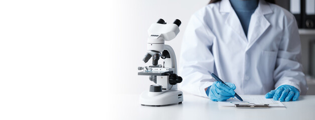 Scientist in a laboratory microscope with microscope slide in hand