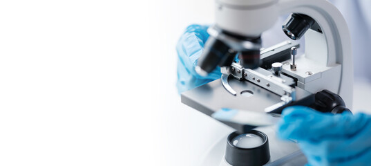 Scientist in a laboratory microscope with microscope slide in hand