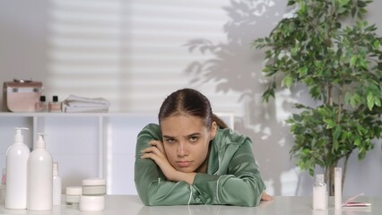 Portrait of a frustrated woman at her dressing table. The disappointed woman is suffering because...