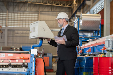 senior engineer manager boss bearded on face in white helmet and worker foreman survey check maintenance heavy machine construction factory after operation process metal sheet