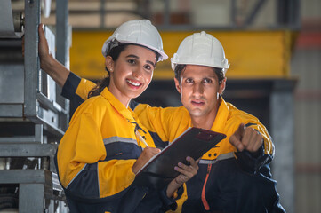 Factory apprenticeship. Man mentor teaching Female employees trainee operating machine looking monitors and check Production process machinery. foreman explaining woman engineer control machine .