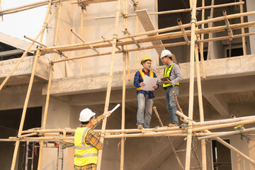 Naklejka na ściany i meble Co-workers discussing architecture projects at construction site at table Architects work with Engineer inspects site for construction project draft, architectural plan