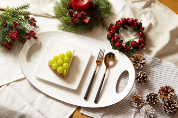 Piece of cake on plate and Christmas decorations on table	