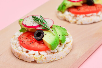 Rice Cake Sandwiches with Avocado, Tomato, Cottage Cheese, Olives and Radish on Wooden Cutting Board. Easy Breakfast. Diet Food. Quick and Healthy Sandwiches. Crispbread with Tasty Filling
