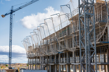 New residential buildings under construction with scaffolding and safety nets, Madrid, Spain.