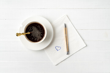 Top view of coffee cup and paper napkins on wooden background