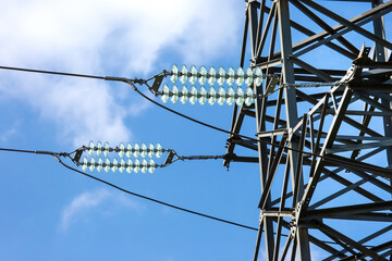 High voltage tower with electrical voltage wires isolates close-up against the background of...